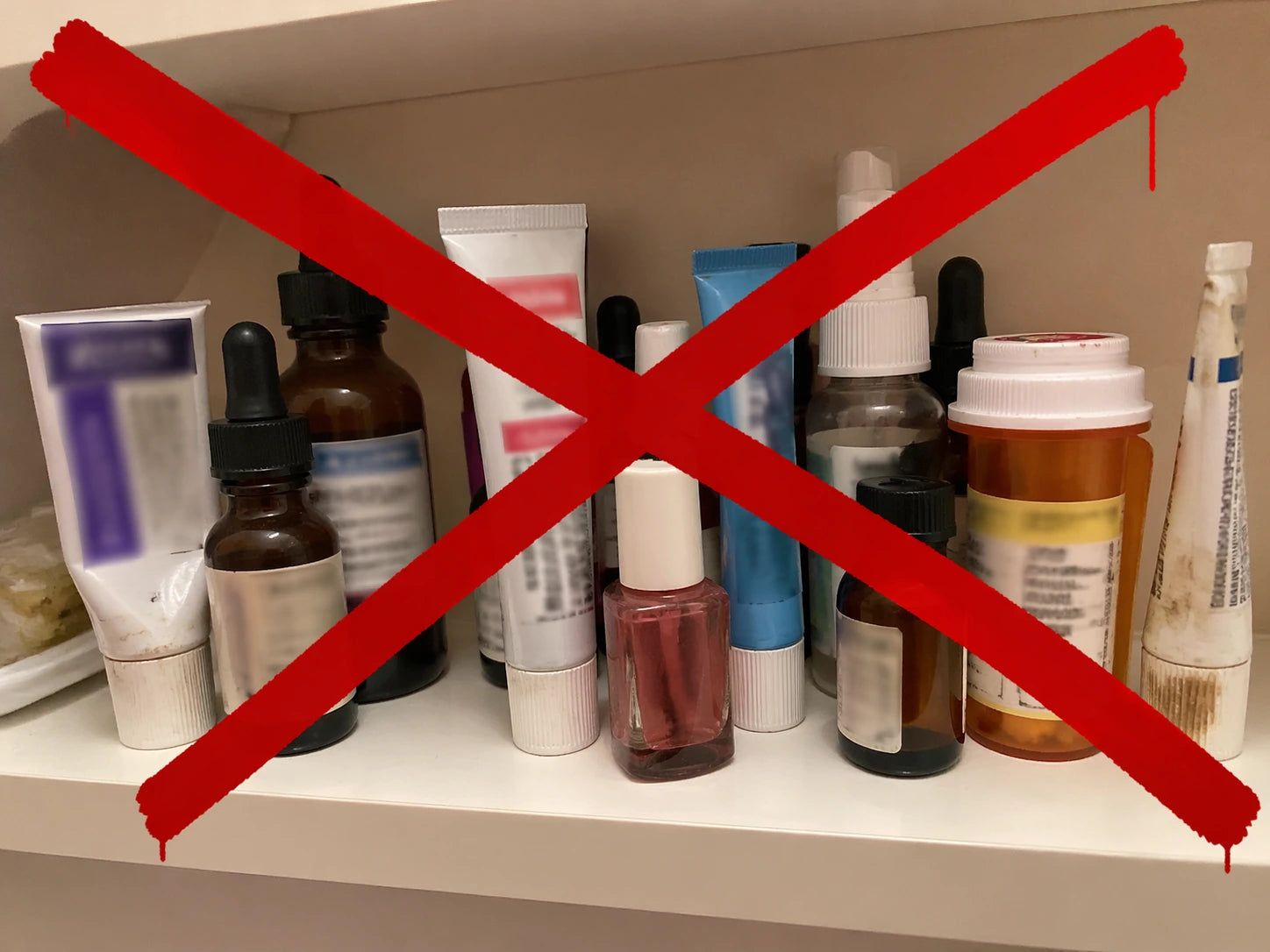 Phone snapshot of a cluttered home bathroom shelf lined with failed nail-fungus products — Kerasal, Jublia, Penlac, tea tree oil bottles side by side, some half-used.