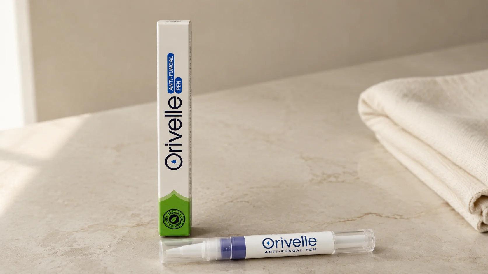 Clean product shot of the Orivelle anti-fungal pen and box on a soft beige marble surface, daylight, no marketing graphics.